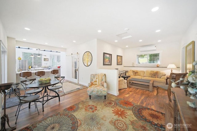 living area featuring recessed lighting, wood finished floors, and a barn door