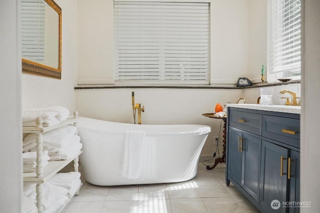 full bath featuring a freestanding bath, tile patterned flooring, and vanity