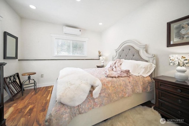 bedroom with baseboards, a wall mounted air conditioner, wood finished floors, and recessed lighting