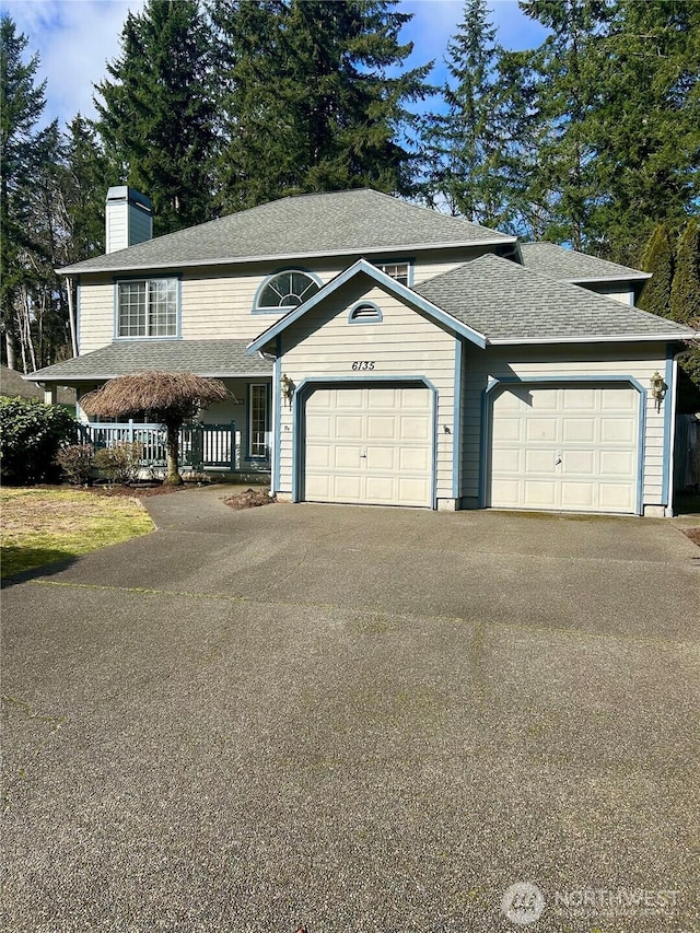 view of front of home featuring a shingled roof, aphalt driveway, an attached garage, and a chimney