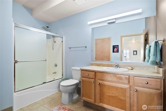 full bathroom with bath / shower combo with glass door, vanity, toilet, and tile patterned floors