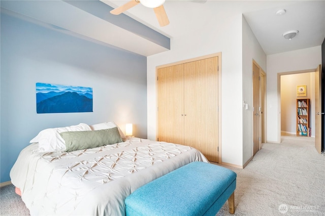 bedroom with ceiling fan, light carpet, and a closet