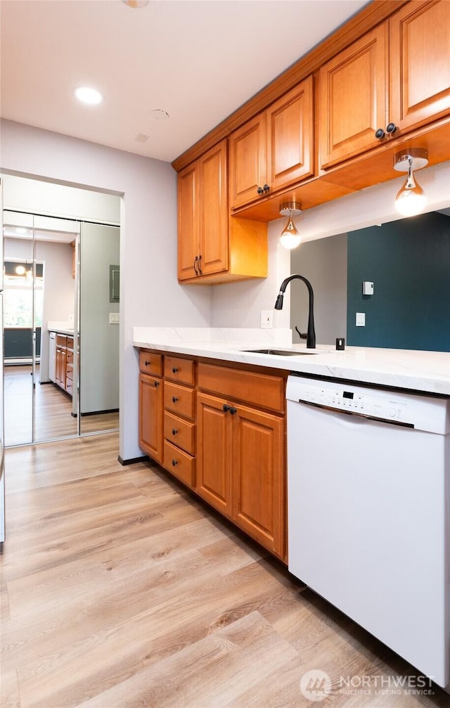 kitchen with sink, light wood-type flooring, and white dishwasher