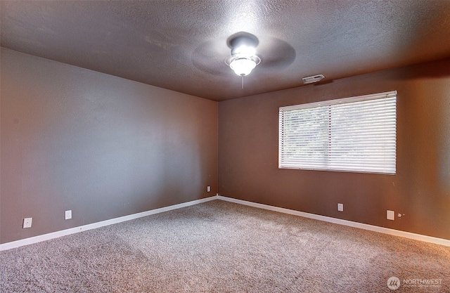 carpeted empty room with ceiling fan and a textured ceiling