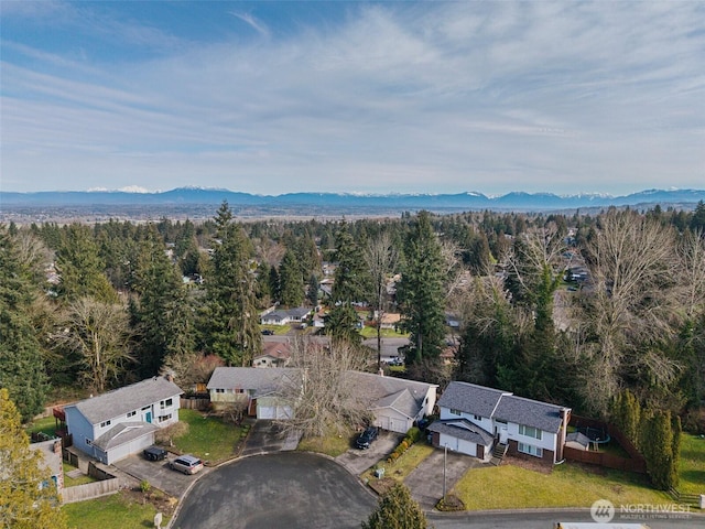 birds eye view of property featuring a forest view and a mountain view