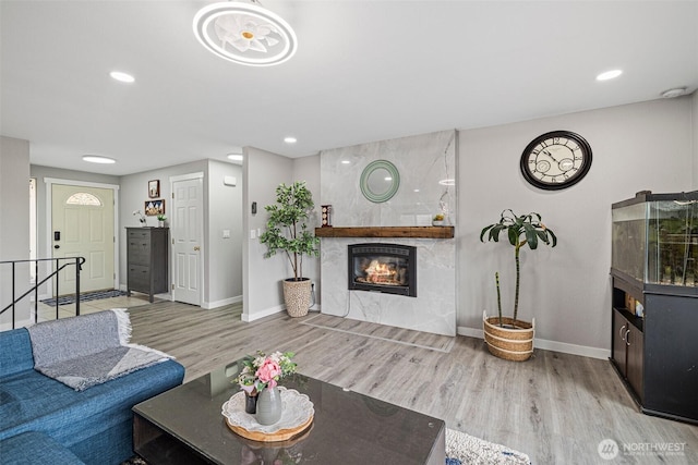 living room with a premium fireplace, wood finished floors, and baseboards