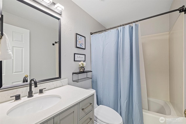 full bathroom featuring shower / bathtub combination with curtain, a textured wall, vanity, and toilet