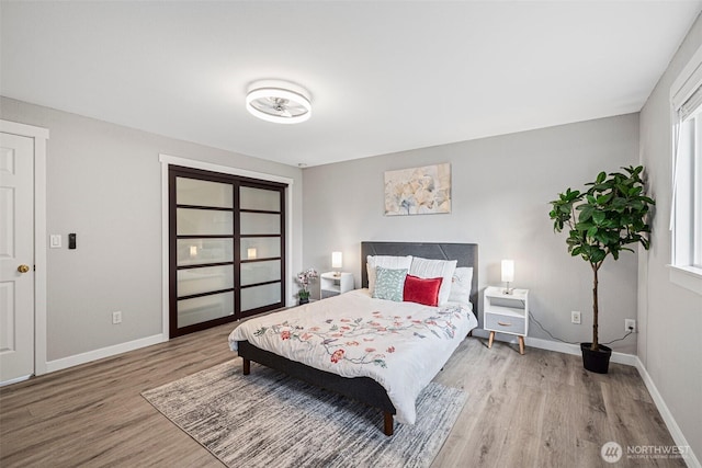 bedroom featuring baseboards and wood finished floors