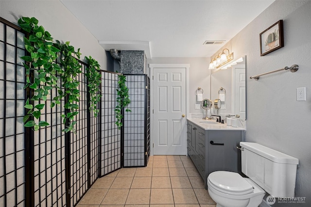 bathroom featuring visible vents, vanity, toilet, and tile patterned floors