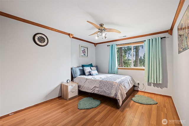 bedroom featuring crown molding, visible vents, and wood finished floors