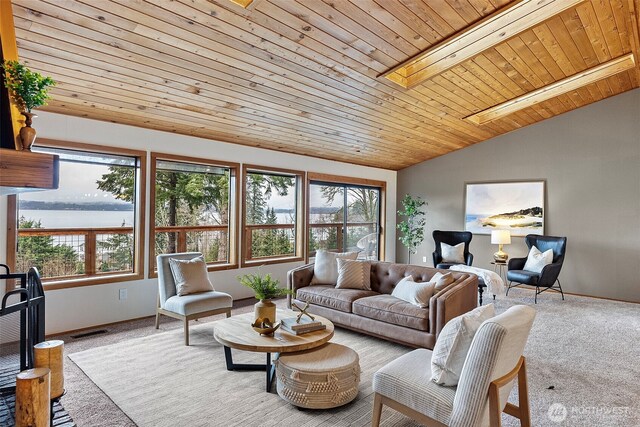 living room with light colored carpet, a water view, plenty of natural light, and visible vents