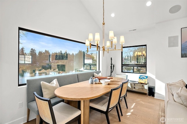 dining space featuring light wood finished floors, lofted ceiling, recessed lighting, a chandelier, and baseboards