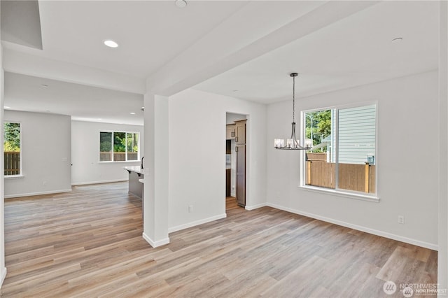 unfurnished room with light wood finished floors, baseboards, a notable chandelier, and recessed lighting