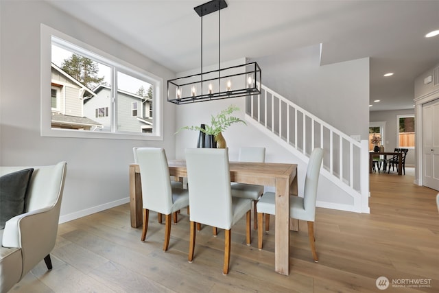 dining area with a notable chandelier, recessed lighting, wood finished floors, baseboards, and stairway