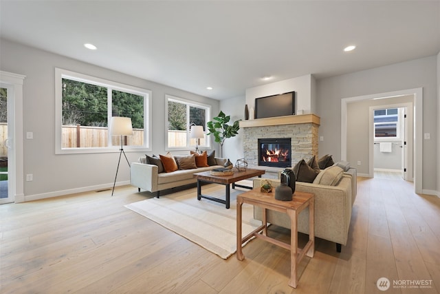 living room with light wood finished floors, a fireplace, baseboards, and recessed lighting