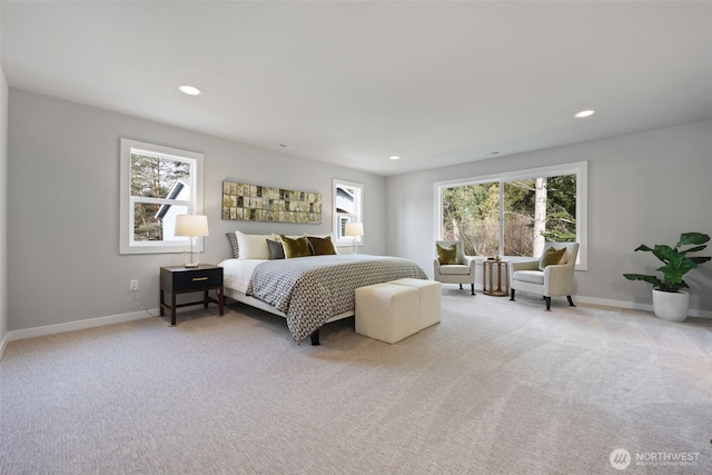 bedroom with light carpet, baseboards, and multiple windows