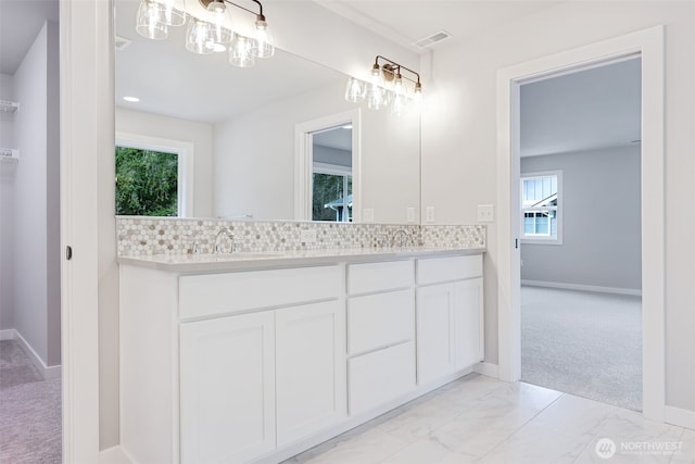 full bath with visible vents, a sink, baseboards, and double vanity