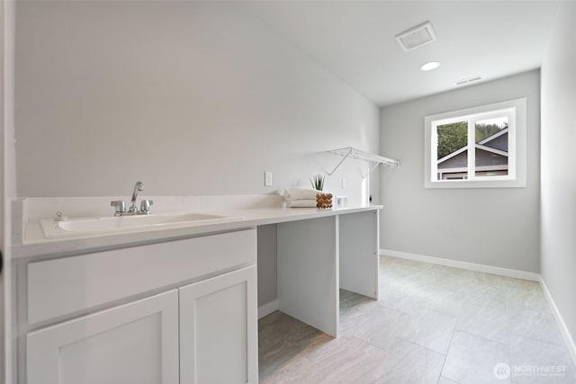 washroom featuring a sink, visible vents, and baseboards