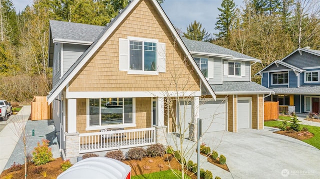 view of front of home featuring a shingled roof, covered porch, and driveway