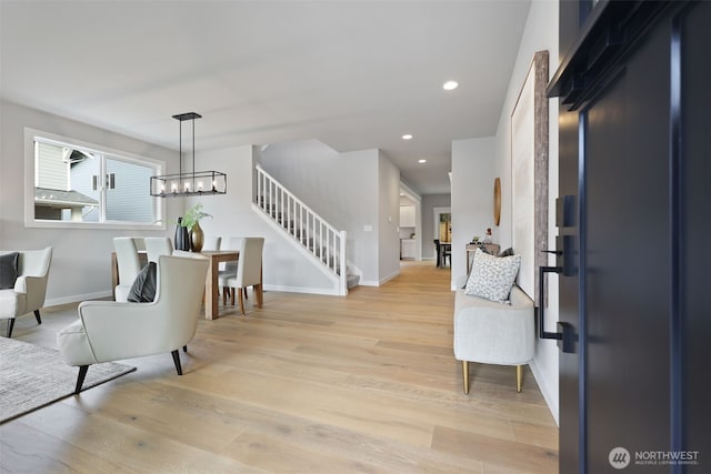 entryway with baseboards, light wood-style flooring, stairs, a notable chandelier, and recessed lighting