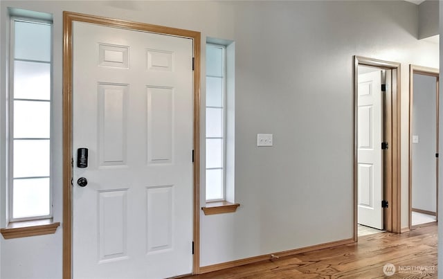 entryway with light wood-type flooring and baseboards