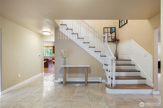 stairs with tile patterned floors, baseboards, and baseboard heating