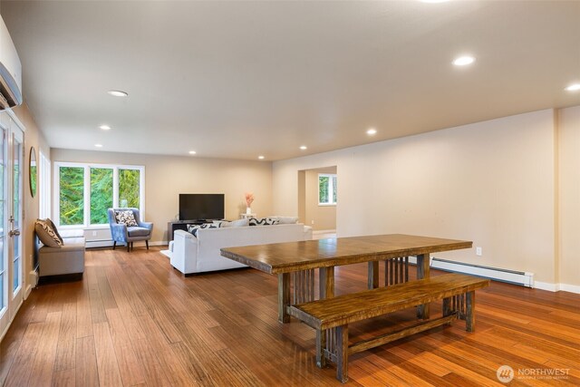 dining space featuring a baseboard radiator, wood finished floors, and recessed lighting