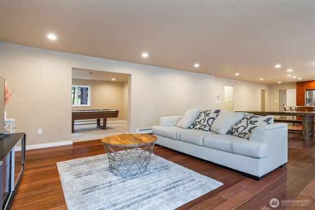 living room featuring a baseboard heating unit, dark wood finished floors, and recessed lighting