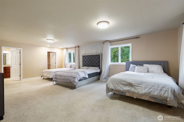 bedroom with baseboards, a spacious closet, multiple windows, and light colored carpet