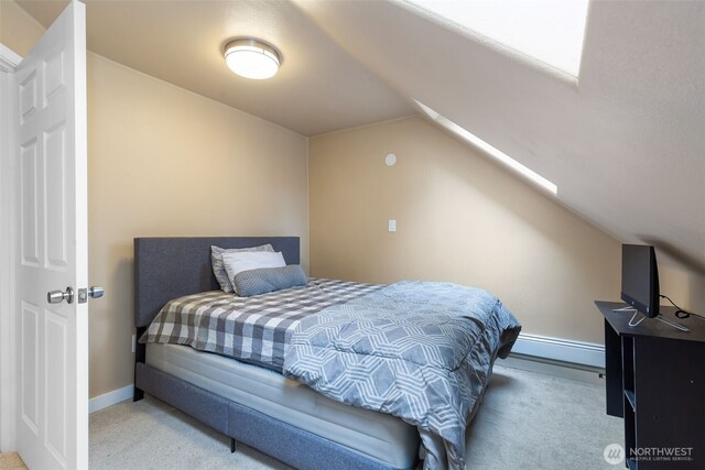 carpeted bedroom with lofted ceiling and baseboards