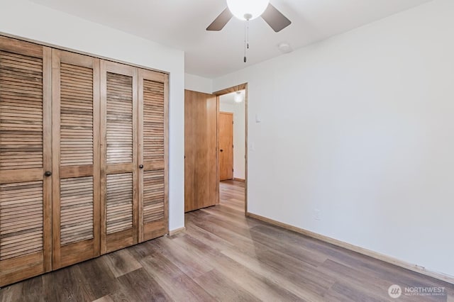 unfurnished bedroom featuring a closet, ceiling fan, and wood-type flooring