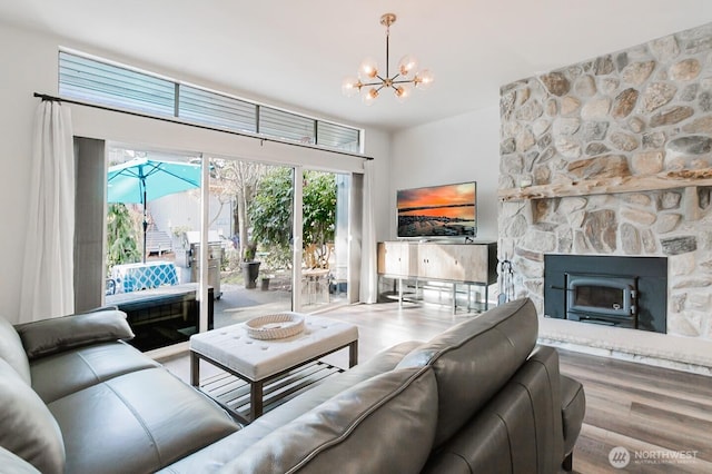 living room featuring hardwood / wood-style floors, a notable chandelier, and a fireplace