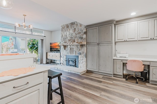 kitchen featuring decorative light fixtures, an inviting chandelier, gray cabinetry, and light hardwood / wood-style flooring