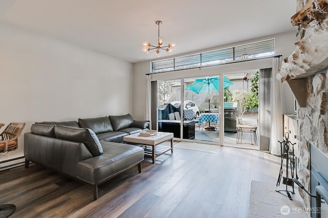 living room featuring an inviting chandelier, dark wood-type flooring, and a fireplace