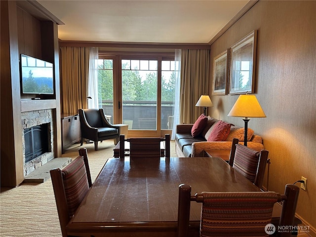 living area with a stone fireplace and carpet