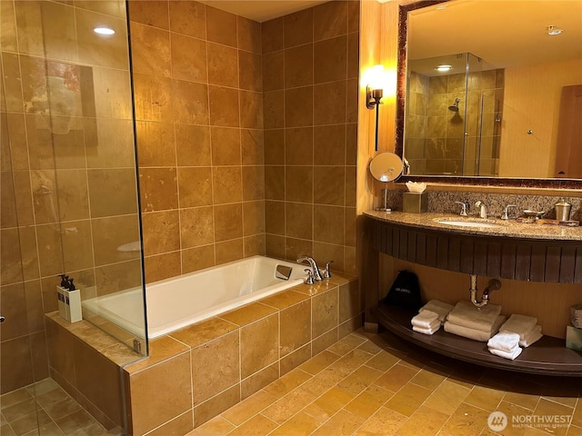 full bath featuring tiled bath, a sink, and tiled shower