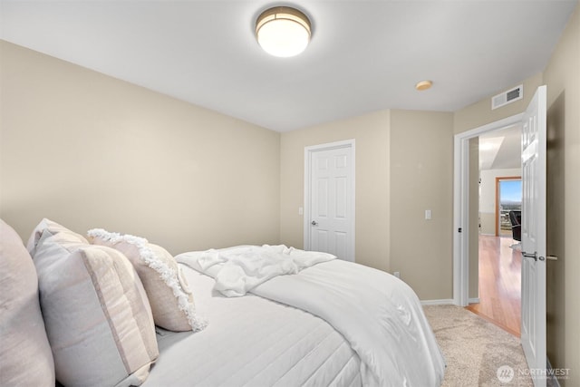 carpeted bedroom with visible vents and baseboards