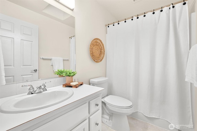 bathroom with curtained shower, vanity, and toilet