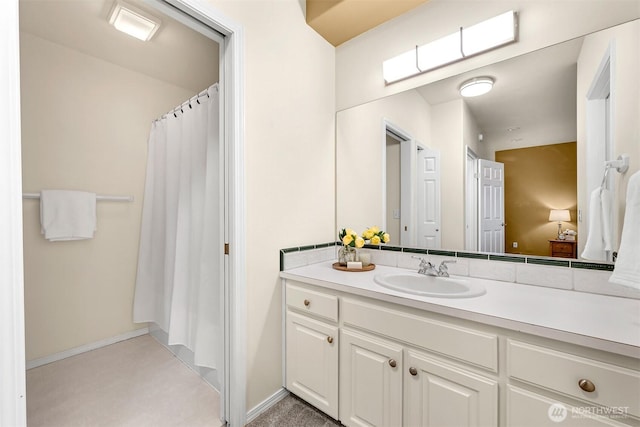 full bathroom with curtained shower, vanity, and baseboards