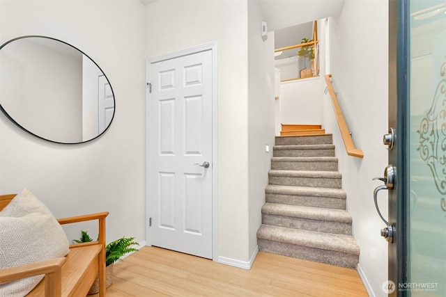 entrance foyer with stairway, wood finished floors, and baseboards