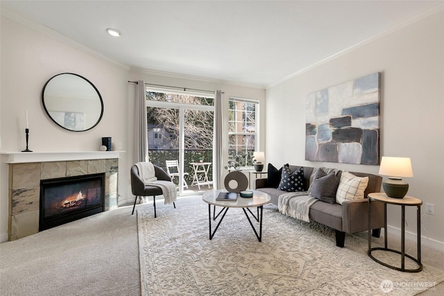 carpeted living area featuring baseboards, a tiled fireplace, and crown molding