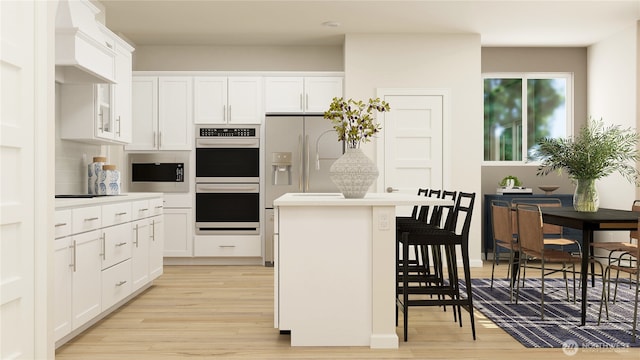 kitchen with stainless steel double oven, a kitchen island, premium range hood, white cabinets, and a kitchen breakfast bar