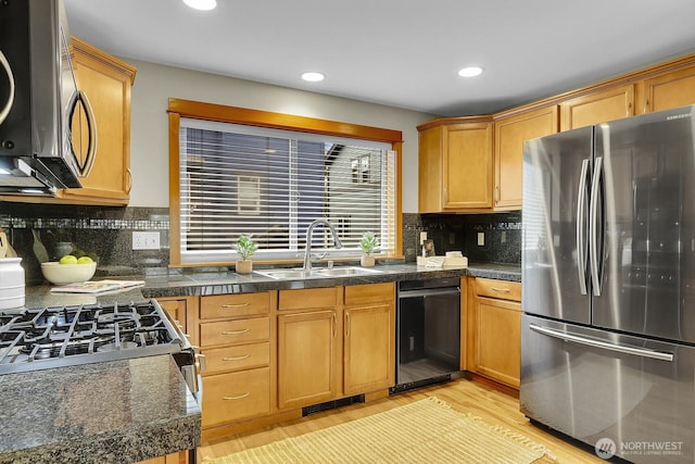 kitchen featuring visible vents, a sink, stainless steel appliances, light wood-type flooring, and backsplash