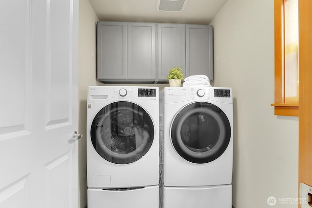 laundry room featuring separate washer and dryer and cabinet space