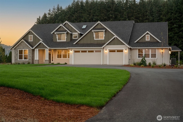 craftsman-style house with a garage and a lawn