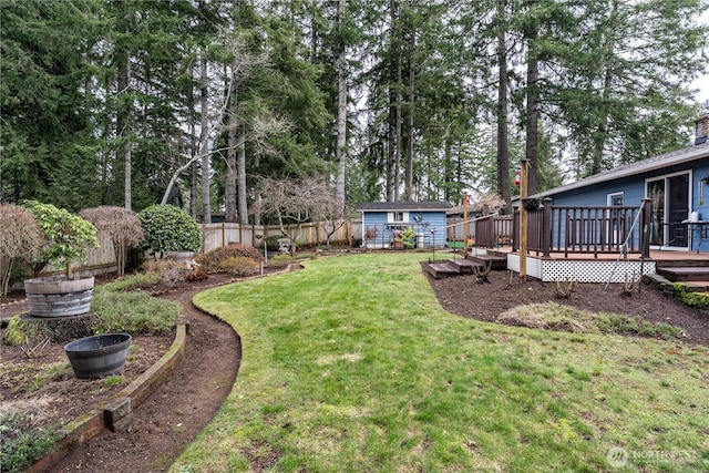 view of yard featuring a fenced backyard, an outdoor structure, and a wooden deck