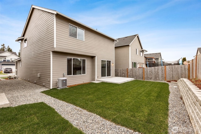 rear view of house featuring a yard, cooling unit, and a patio area