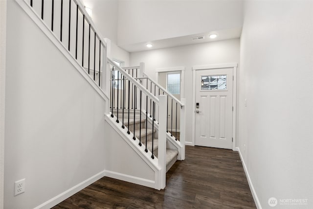 entrance foyer featuring dark hardwood / wood-style flooring and a towering ceiling