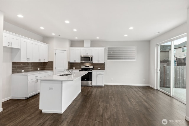 kitchen featuring white cabinetry, sink, appliances with stainless steel finishes, and a kitchen island with sink