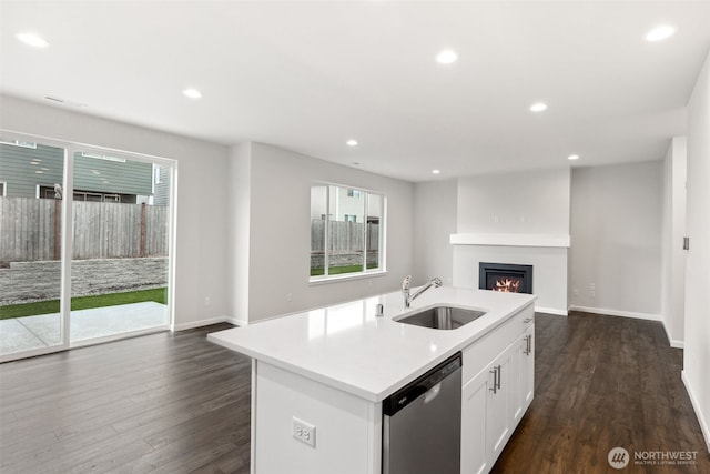 kitchen featuring sink, dark hardwood / wood-style flooring, stainless steel dishwasher, white cabinets, and an island with sink